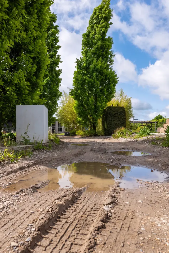 Before: a compacted dirt and gravel lot with tire tracks and puddles